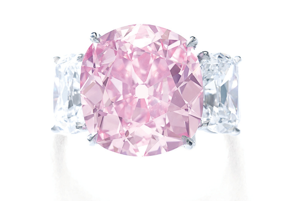 Pink diamond set amongst 2 white diamonds